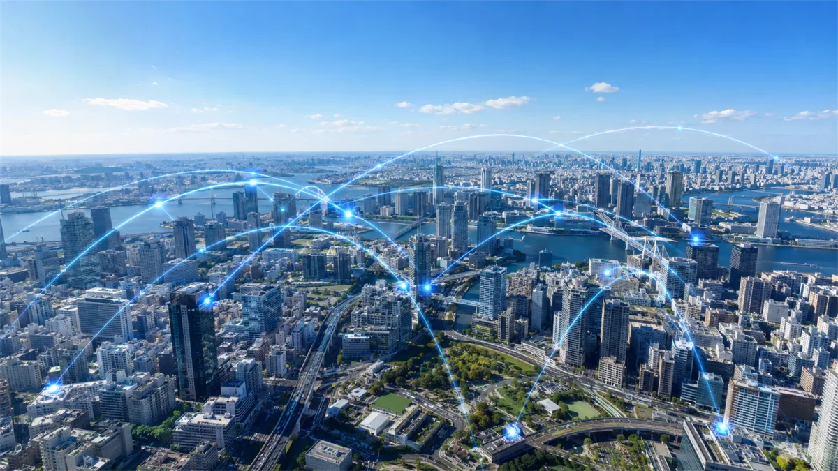 an aerial city view is overlaid with blue arcs and nodes linking districts, roads, and buildings, creating a broad smart-city image for digital planning, municipal networks, and urban data services.