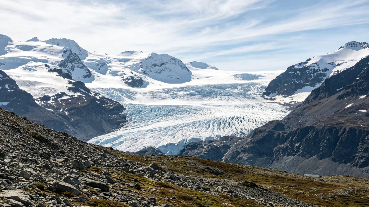 a smooth blue-white arctic dome mountain rises from a frozen plain at twilight.
