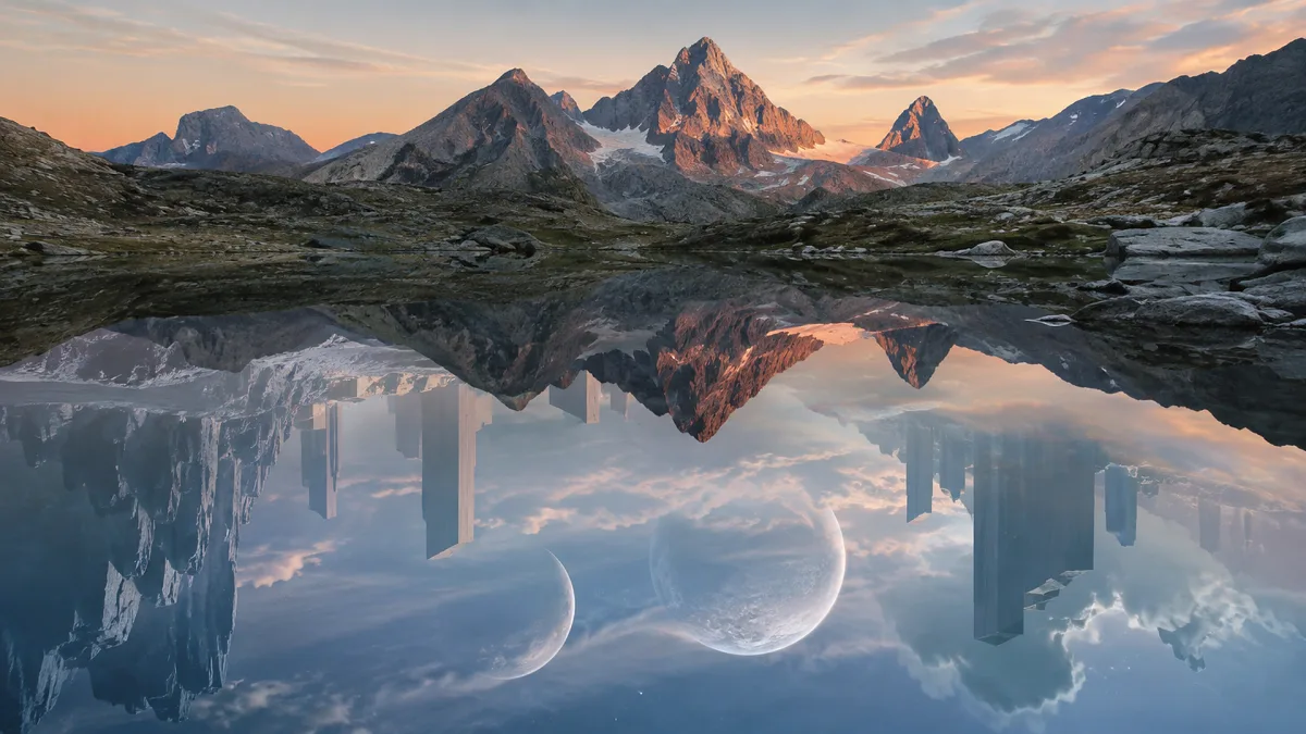 Snowy mountains and abstract moon shapes reflect in a still lake like a double landscape.