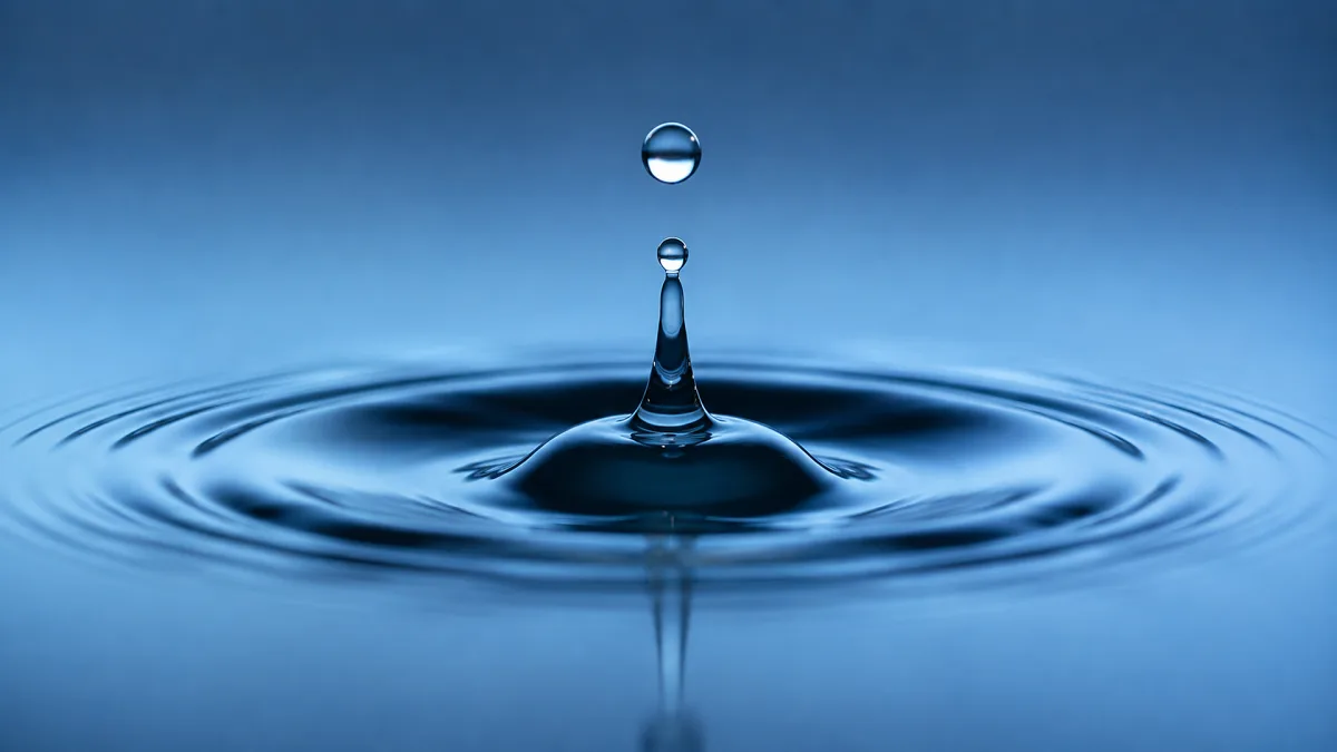 A single water droplet rises from ripples, suggesting clean water and renewable energy.