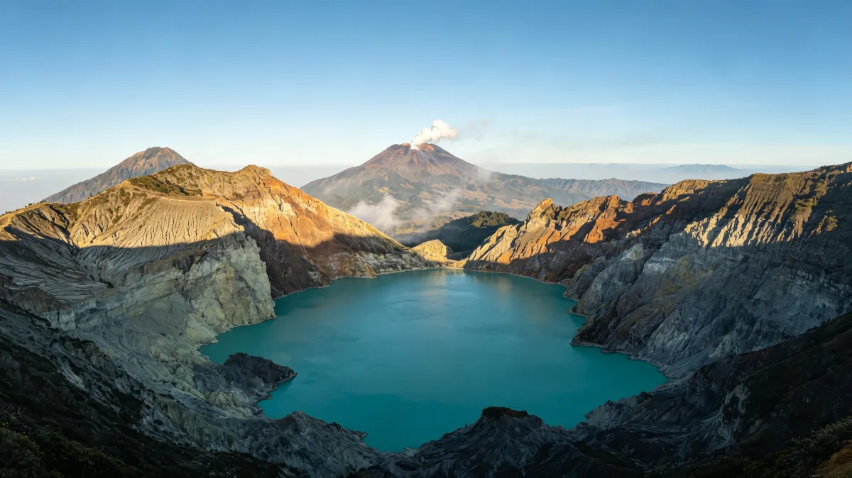 a wide volcanic crater lake glows turquoise beneath rugged ridges and distant steam.