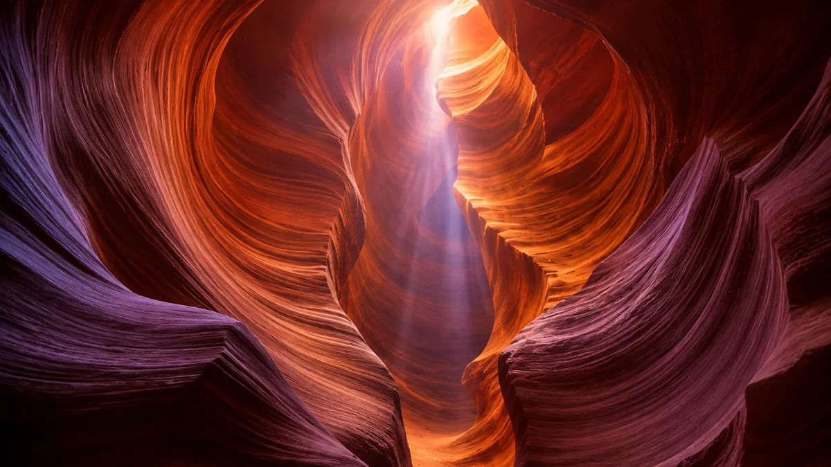 sunbeam shining through red slot canyon walls